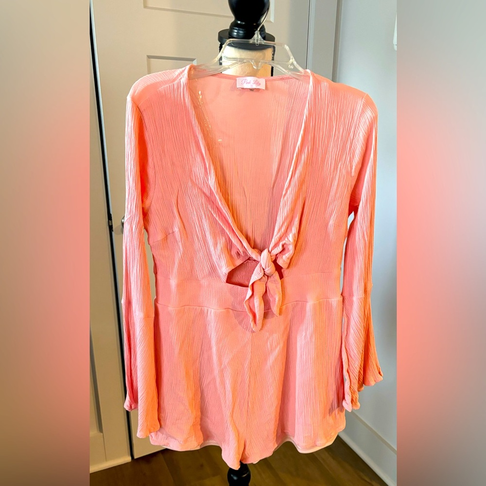 Pink Lily shorts romper set.  Ties at chest with peep hole at stomach. Size S